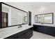 Spacious bathroom with dual vanities, large mirrors, and modern black cabinetry at 33949 N Borgata Trl, San Tan Valley, AZ 85144