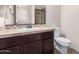 Cozy bathroom featuring dark wood cabinets, neutral countertops, and a classic sink with a toilet at 4102 E Crescent Way, Chandler, AZ 85249