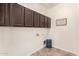 Laundry room features built-in upper cabinets and tile flooring at 4102 E Crescent Way, Chandler, AZ 85249