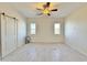 Neutral bedroom with modern ceiling fan, tile flooring and a sliding barn door at 4240 N Arizona Rd, Eloy, AZ 85131