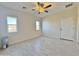 Sunlit bedroom with tile flooring, ceiling fan, and serene outdoor views from two windows at 4240 N Arizona Rd, Eloy, AZ 85131