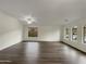 Bright living room featuring neutral walls, ceiling fan, ample natural light from the arched windows, and hard surface floors at 42618 W Oakland Dr, Maricopa, AZ 85138