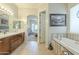 Inviting bathroom with a soaking tub, double vanity, and entrance to the primary bedroom at 4315 W Phalen Dr, New River, AZ 85087