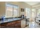 Kitchen sink with stone countertop, and breakfast nook with wine cooler in the background at 4315 W Phalen Dr, New River, AZ 85087