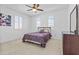 Bedroom showcases a comfortable bed, carpeted floors, arched windows, and a ceiling fan for a relaxing retreat at 4321 E Zion Way, Chandler, AZ 85249