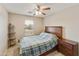 This carpeted bedroom features a window, ceiling fan, and classic furnishings at 43870 W Baker Dr, Maricopa, AZ 85138