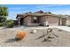 Single-story home with a two-car garage, low maintenance landscape, and neutral toned exterior paint at 43870 W Baker Dr, Maricopa, AZ 85138