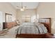 Spacious main bedroom featuring a ceiling fan, large window and ensuite bath access at 43870 W Baker Dr, Maricopa, AZ 85138