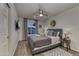 A well-lit bedroom with a ceiling fan, wood floor, and a comfy bed with decorative pillows at 4826 W Michigan Ave, Glendale, AZ 85308