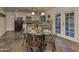 Cozy dining area featuring a round glass table with seating and natural light, complemented by an open kitchen design at 4826 W Michigan Ave, Glendale, AZ 85308