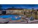 Beautifully lit backyard pool with stone patio, lounge chairs, and outdoor lighting at twilight at 4826 W Michigan Ave, Glendale, AZ 85308