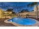 An inviting backyard pool with stone surround, covered patio, and lush landscaping at twilight at 4826 W Michigan Ave, Glendale, AZ 85308