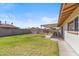 Spacious backyard featuring a large, grassy area, covered patio, and block wall for privacy at 5255 W Caribbean Ln, Glendale, AZ 85306