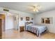 Light-filled bedroom with wood floors, ceiling fan, and access to an ensuite bathroom and closet at 5255 W Caribbean Ln, Glendale, AZ 85306