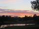 Picturesque golf course pond at sunset, framed by trees with a mountain in the background at 6832 S 38Th S Pl, Phoenix, AZ 85042