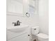 Elegant half bathroom with a sleek white vanity, modern fixtures, and a window with stylish blinds at 7815 W Monte Vista Rd, Phoenix, AZ 85035