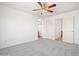 Well-lit bedroom with gray carpeting, ceiling fan and entryways to other rooms at 7815 W Monte Vista Rd, Phoenix, AZ 85035