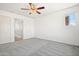 Bright bedroom with ceiling fan, plush carpet and natural light from the window at 7815 W Monte Vista Rd, Phoenix, AZ 85035