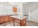 Charming kitchen with wood cabinets, island, and a unique glass block window that provides plenty of natural light at 7815 W Monte Vista Rd, Phoenix, AZ 85035