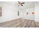 Bright living room featuring wood-look floors, an open layout, and a ceiling fan for added comfort at 7815 W Monte Vista Rd, Phoenix, AZ 85035