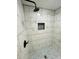 A modern shower with white marble-patterned tile and a mosaic tile floor at 8139 W Columbine Dr, Peoria, AZ 85381