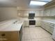 Traditional kitchen featuring white cabinets, tile flooring, and a suite of appliances for convenient meal preparation at 8255 E Kiva Ave # 424, Mesa, AZ 85209