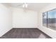 Bright bedroom with plush carpet, sloped ceiling, and large windows offering backyard views at 8818 N 110Th Ave, Peoria, AZ 85345