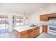 Bright kitchen showcasing wooden cabinets, a double sink, and an adjacent dining area with backyard access at 8818 N 110Th Ave, Peoria, AZ 85345