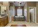 A luxurious bathroom with a soaking tub and glass block window at 9331 E Mclellan Rd, Mesa, AZ 85207