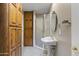 Bright bathroom featuring a pedestal sink, shower, and wooden cabinets for ample storage at 9331 E Mclellan Rd, Mesa, AZ 85207