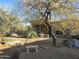 Desert property featuring mature trees, desert landscaping, and a custom bench at 9331 E Mclellan Rd, Mesa, AZ 85207