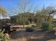 Desert property featuring mature trees, desert landscaping, and an antique ore cart at 9331 E Mclellan Rd, Mesa, AZ 85207