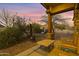 Outdoor living space with stone columns, flagstone table, and an antique wood stove at 9331 E Mclellan Rd, Mesa, AZ 85207