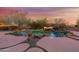 Beautiful backyard pool featuring rock waterfall and mature desert landscaping at sunset at 9331 E Mclellan Rd, Mesa, AZ 85207