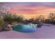 Stunning pool area at sunset with rock features and lush desert landscaping at 9331 E Mclellan Rd, Mesa, AZ 85207