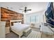 Comfortable bedroom with wood accent wall, ceiling fan, and plenty of natural light at 993 E Knightsbridge Way, Gilbert, AZ 85297