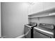 Laundry room with front-load washer and dryer and white upper cabinets and shelving at 993 E Knightsbridge Way, Gilbert, AZ 85297