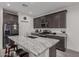 Kitchen with island, granite countertops, stainless steel appliances, dark wood cabinetry, and barstool seating at 10986 W Polk St, Avondale, AZ 85323