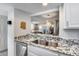 Updated kitchen with granite countertops, stainless steel sink, and open view to the living room at 11011 N 92Nd St # 1157, Scottsdale, AZ 85260
