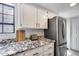 Bright kitchen features granite countertops, stainless steel appliances, and white cabinets at 11011 N 92Nd St # 1157, Scottsdale, AZ 85260