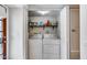 Functional laundry room showcasing a washer and dryer, wooden shelf, and white cabinets at 11011 N 92Nd St # 1157, Scottsdale, AZ 85260