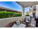 Cozy covered patio features comfortable wicker seating, stylish rug, and a view of the well-maintained landscaping at 11011 N 92Nd St # 1157, Scottsdale, AZ 85260