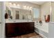 Bathroom featuring a soaking tub, double sink vanity, and a walk-in shower at 11023 E Shepperd Ave, Mesa, AZ 85212