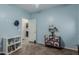 Bright bedroom featuring tile floors, blue walls, and adjacent laundry room access at 11023 E Shepperd Ave, Mesa, AZ 85212