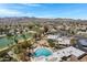 Scenic aerial view of the community showcasing the pool, golf course, and mountain views against a bright, blue sky at 12007 S Crow Ct, Phoenix, AZ 85044