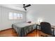 Bright bedroom with hardwood floors, shutters, ceiling fan, and a desk at 12007 S Crow Ct, Phoenix, AZ 85044