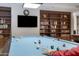 Community center game room with a billiards table and bookcase-lined walls at 12007 S Crow Ct, Phoenix, AZ 85044