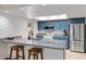 Bright kitchen with stainless appliances, granite counters, bar stool seating, and a sunlit skylight at 12007 S Crow Ct, Phoenix, AZ 85044