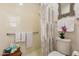 Bright bathroom featuring a shower with curtain, decorative mirror, and coordinated towels with a pop of color from an orchid at 1209 E Park Ave, Chandler, AZ 85225
