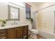 Bright bathroom featuring a shower with curtain, decorative mirror, wooden cabinetry, and greenery at 1209 E Park Ave, Chandler, AZ 85225